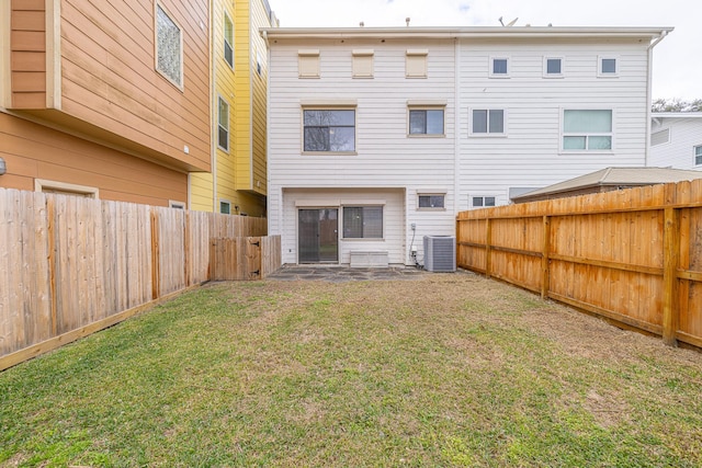 back of house featuring a lawn and central air condition unit