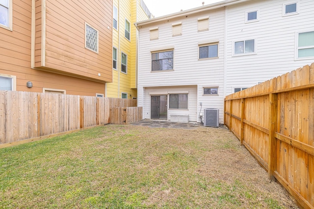 back of property featuring central AC and a lawn