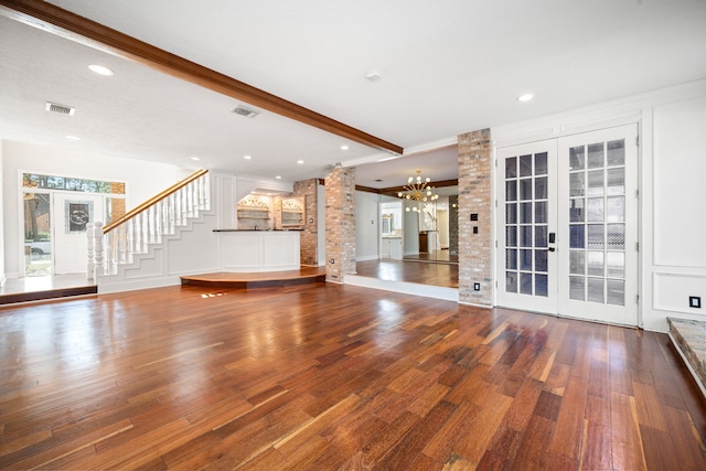 unfurnished living room featuring french doors, hardwood / wood-style flooring, and beamed ceiling