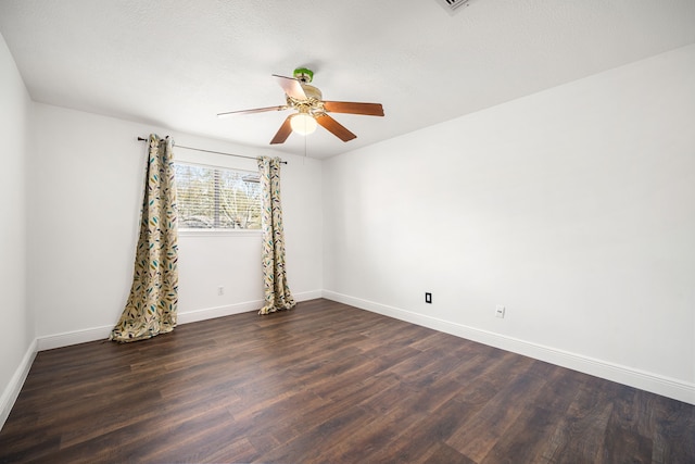 empty room with dark hardwood / wood-style floors and ceiling fan