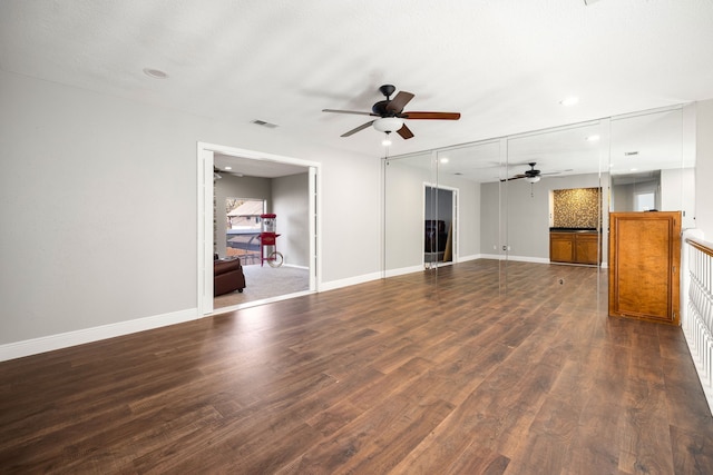 unfurnished living room with ceiling fan and dark hardwood / wood-style flooring