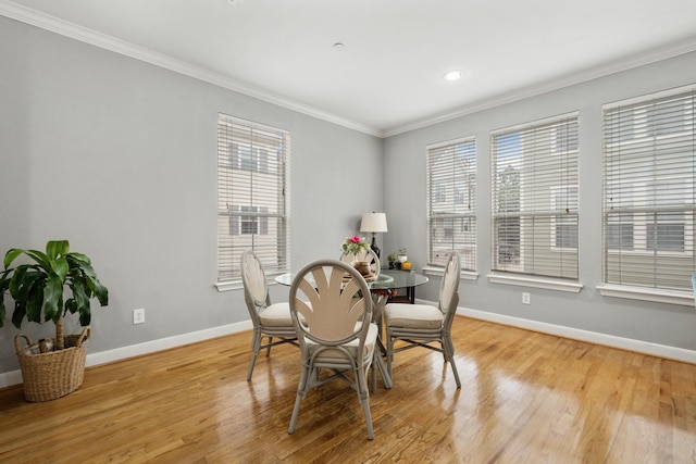 dining area featuring ornamental molding and light wood-type flooring