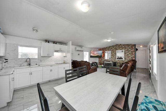 dining room with sink, vaulted ceiling, and a wall unit AC