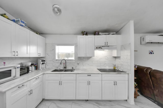 kitchen featuring a wall mounted air conditioner, sink, white cabinets, backsplash, and black electric cooktop