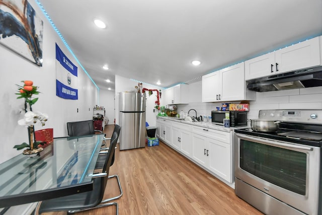 kitchen with sink, appliances with stainless steel finishes, backsplash, white cabinets, and light wood-type flooring