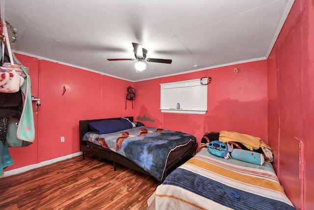 bedroom with crown molding, dark hardwood / wood-style floors, and ceiling fan