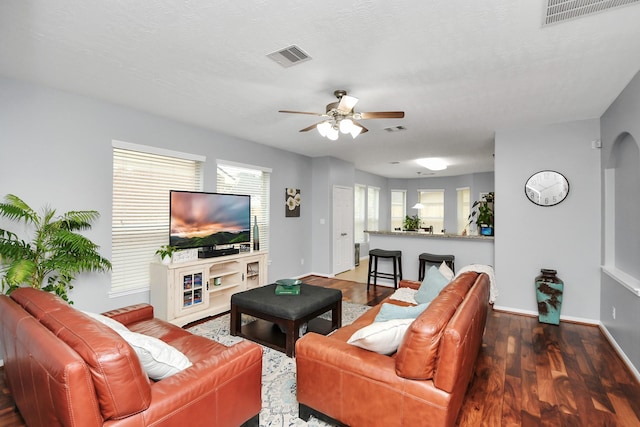 living room featuring a textured ceiling, dark hardwood / wood-style floors, and ceiling fan