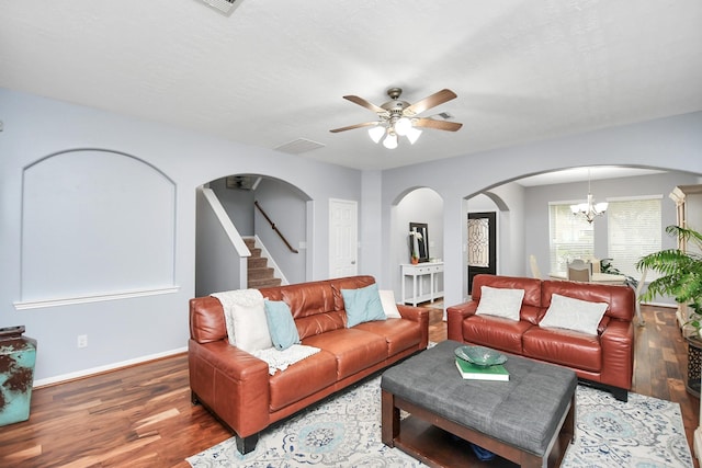 living room featuring hardwood / wood-style flooring, ceiling fan with notable chandelier, and a textured ceiling