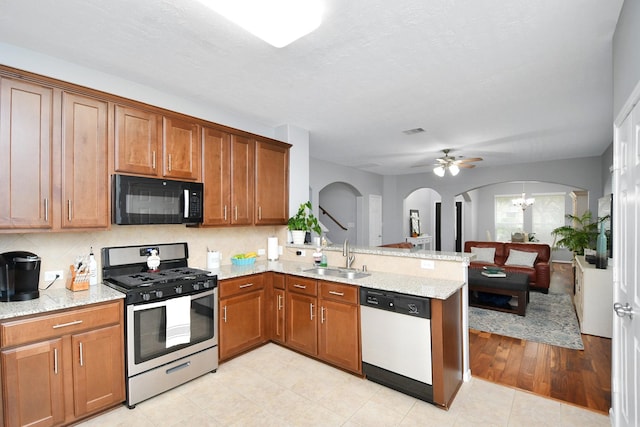 kitchen with dishwashing machine, sink, stainless steel gas stove, decorative backsplash, and kitchen peninsula