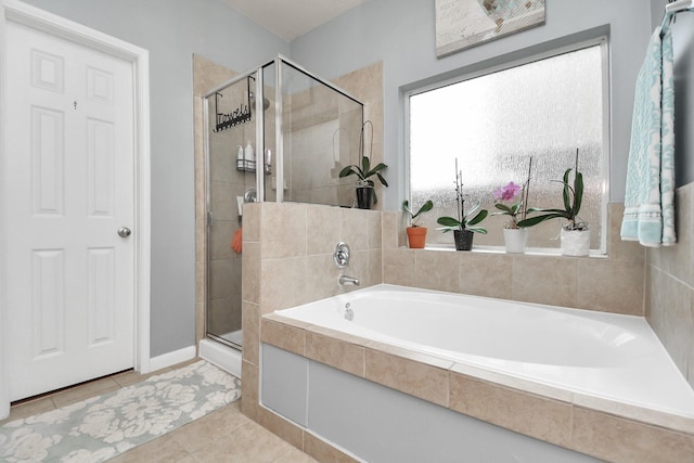 bathroom with tile patterned flooring and shower with separate bathtub