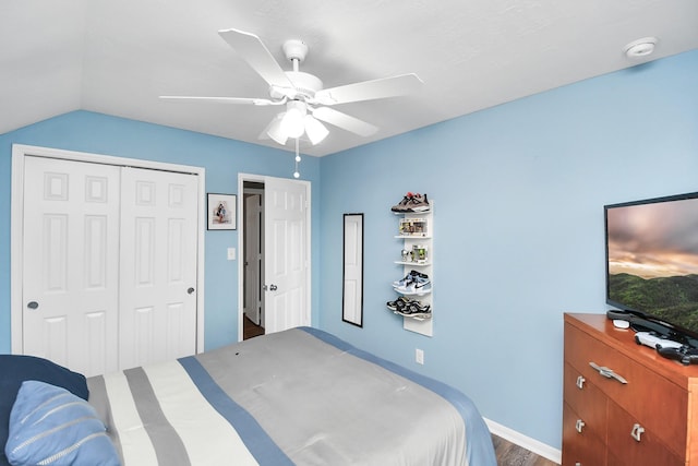 bedroom featuring hardwood / wood-style flooring, vaulted ceiling, a closet, and ceiling fan