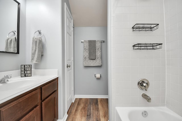 bathroom with vanity, hardwood / wood-style flooring, and tiled shower / bath