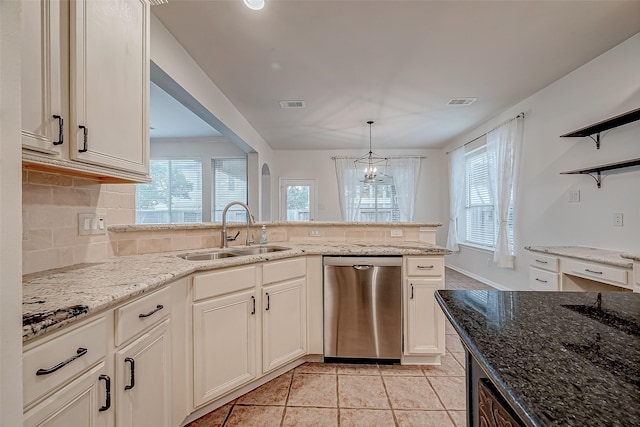 kitchen featuring pendant lighting, sink, decorative backsplash, stainless steel dishwasher, and light stone counters