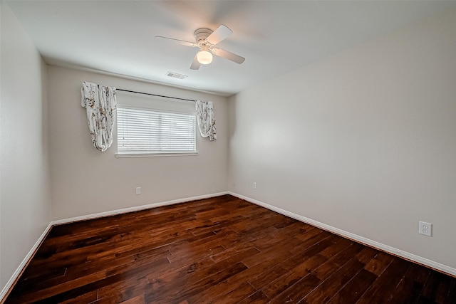 unfurnished room featuring dark wood-style floors, a ceiling fan, and baseboards