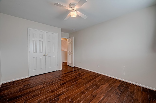 unfurnished bedroom featuring ceiling fan, dark hardwood / wood-style flooring, and a closet