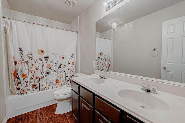 bathroom with wood finished floors, toilet, shower / tub combo, and double vanity