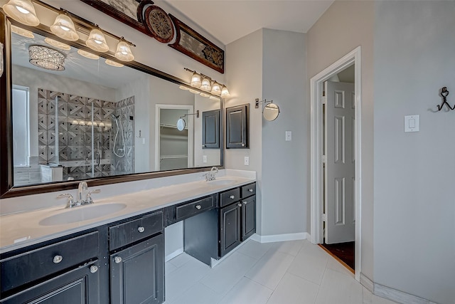 bathroom with tile patterned flooring, tiled shower, double vanity, and baseboards