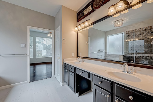 full bath featuring tile patterned floors, double vanity, a ceiling fan, and baseboards