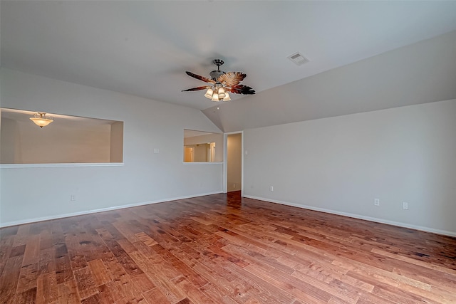 spare room with a ceiling fan, wood finished floors, lofted ceiling, and baseboards