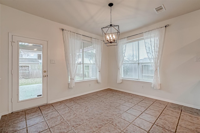 unfurnished dining area featuring a chandelier, light tile patterned floors, and baseboards