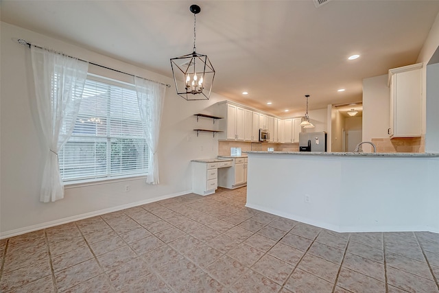 kitchen featuring hanging light fixtures, white cabinets, and appliances with stainless steel finishes