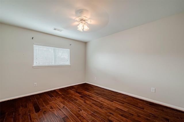 spare room featuring dark wood-type flooring, baseboards, and a ceiling fan