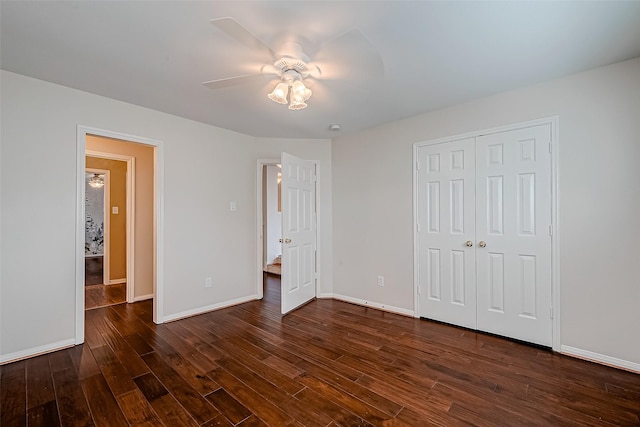unfurnished bedroom with dark wood finished floors, baseboards, a closet, and a ceiling fan