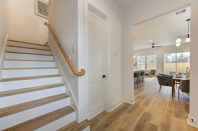 stairs featuring baseboards, visible vents, ceiling fan, and wood finished floors