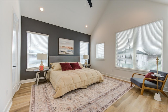 bedroom featuring multiple windows, light wood-type flooring, and baseboards