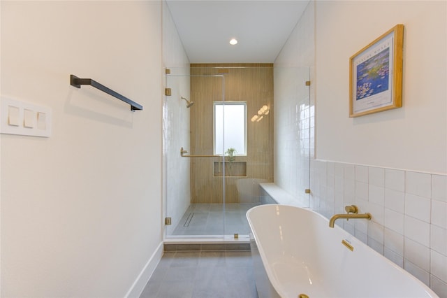 full bath with recessed lighting, tile walls, baseboards, a freestanding bath, and a shower stall