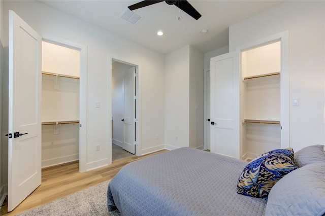 bedroom with light wood-style flooring, a walk in closet, and a closet