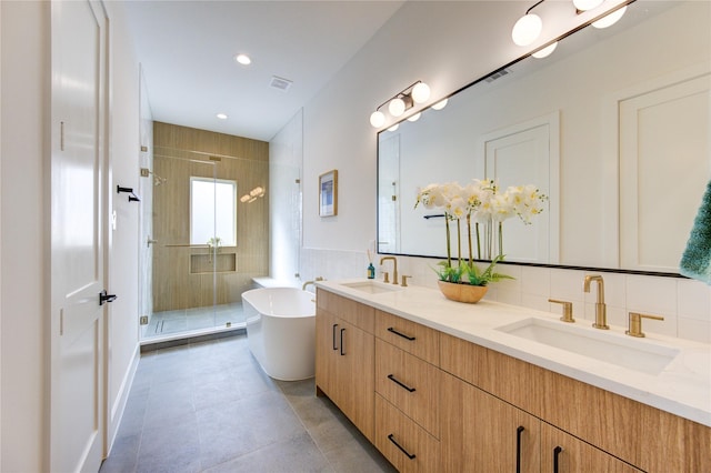 full bathroom with a freestanding bath, double vanity, a sink, and a shower stall