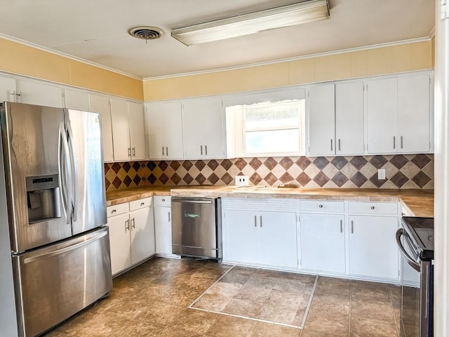 kitchen with tasteful backsplash, stainless steel appliances, crown molding, and white cabinets