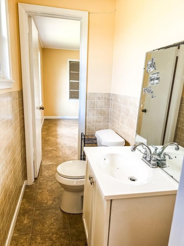 bathroom with vanity, tile patterned flooring, toilet, and tile walls