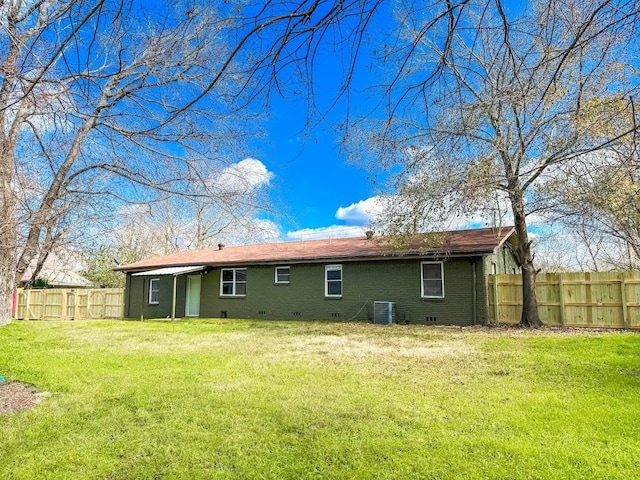 rear view of property with cooling unit and a lawn