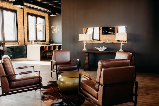 interior space with sink, hardwood / wood-style flooring, and brick wall