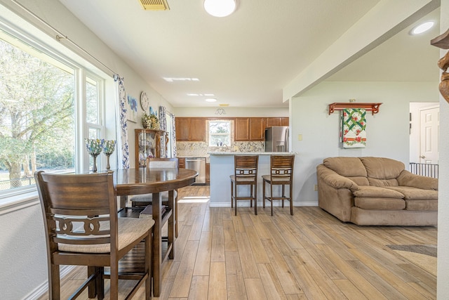 dining space featuring light wood-style flooring and baseboards