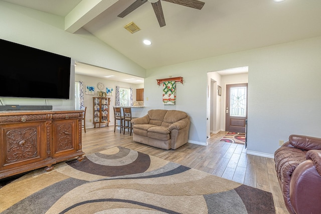 living room with vaulted ceiling with beams, ceiling fan, visible vents, baseboards, and light wood-style floors