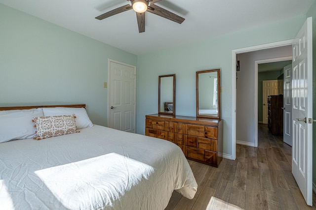 bedroom featuring a ceiling fan, baseboards, and wood finished floors