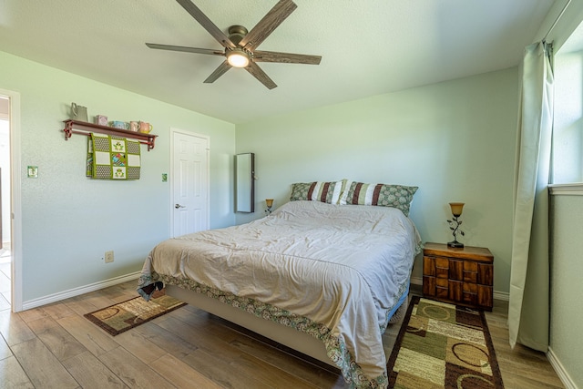 bedroom featuring light wood-type flooring, ceiling fan, and baseboards