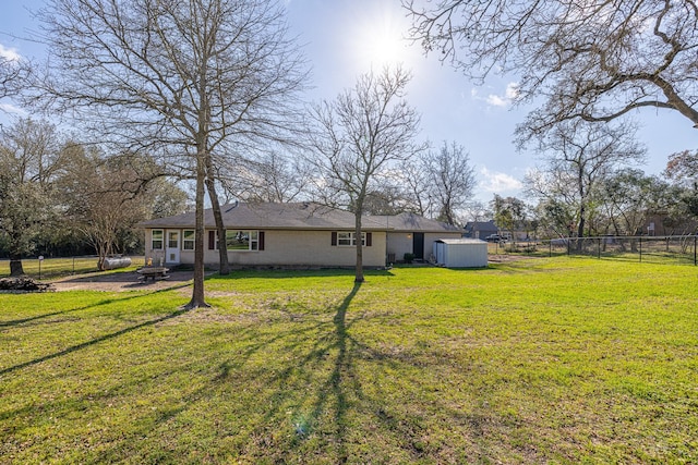 view of yard with a shed, a fenced backyard, and an outdoor structure