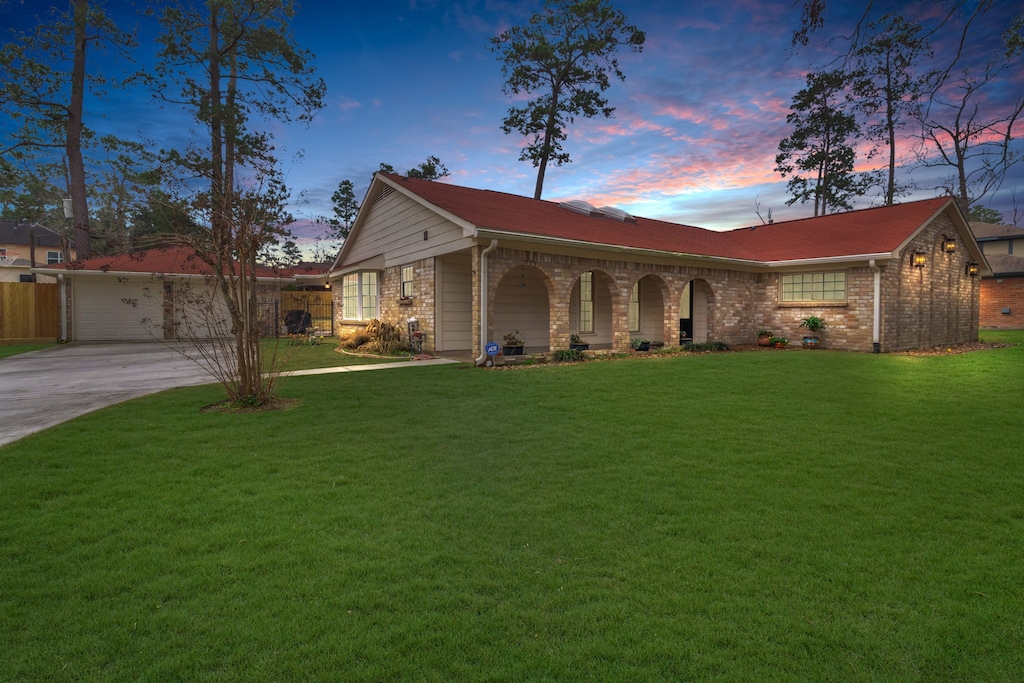 ranch-style house featuring a garage and a lawn