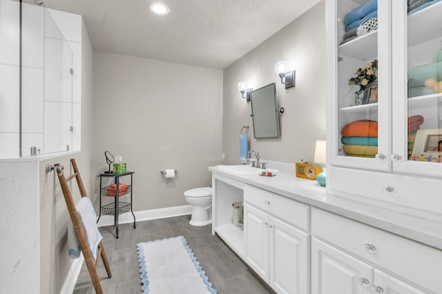 bathroom featuring vanity, hardwood / wood-style floors, and toilet