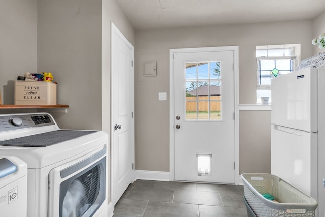 washroom featuring dark tile patterned flooring and washing machine and dryer