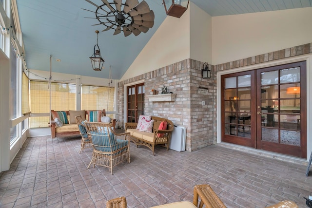 unfurnished sunroom featuring lofted ceiling, ceiling fan, and french doors