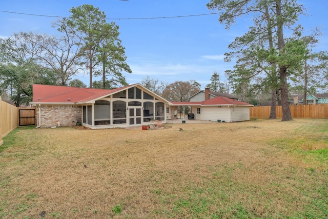 back of property featuring a yard and a sunroom