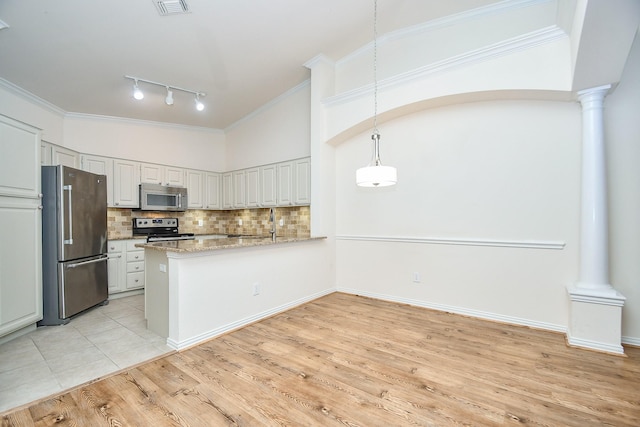 kitchen with stainless steel appliances, decorative light fixtures, decorative columns, and white cabinets