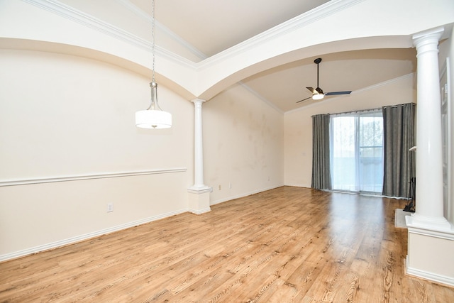 spare room featuring light wood finished floors, vaulted ceiling, a ceiling fan, ornamental molding, and decorative columns
