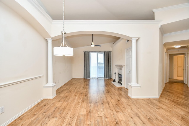 unfurnished living room featuring ornamental molding, a fireplace with raised hearth, decorative columns, and light wood-style flooring