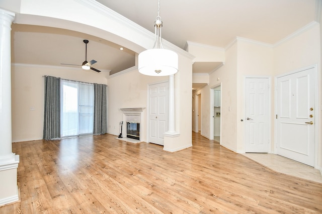 unfurnished living room with ornamental molding, decorative columns, ceiling fan, and light wood-type flooring